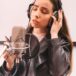 female vocalist singing at microphone